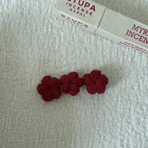 Detail of handcrafted burgundy crochet floral hair clips with soft knit textures