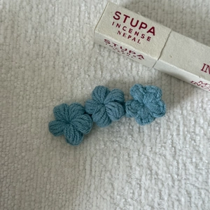 Macro shot of blue handmade crochet flower hair clip with detailed knit texture