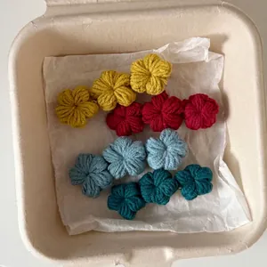 Set of four handmade crochet flower hair clips in vibrant blue and yellow colors