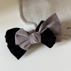 Close-up of velvet layered bow hair clip featuring elegant black and mauve purple tones