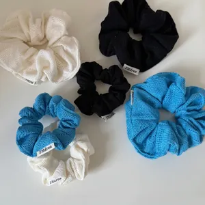 Blue and cream knit scrunchie set in various sizes with woven texture for ponytails
