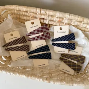 Set of 2 plaid fabric hair clips in autumn colors on a minimalist display card