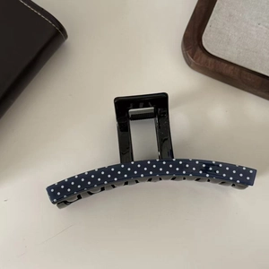Detail view of navy blue polka dot acetate claw clip with anti-slip inner teeth