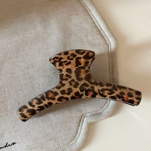 Macro detail of high-quality leopard print hair claw clip with glossy acetate texture