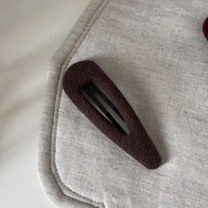 Close-up of retro brown ribbed fabric hair clip with a durable black metal BB grip
