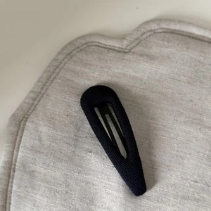 Detail view of the black ribbed fabric wrapped BB hair clip with metal inner clip