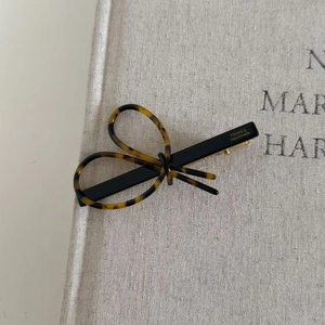 Détail de la pince à cheveux noeud en écaille avec lettrage France Handmade doré