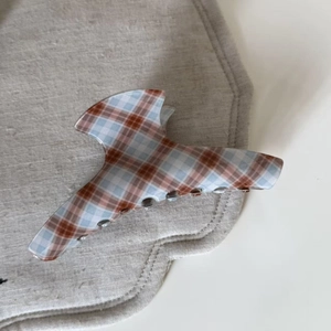 Detailed view of the vintage plaid acetate hair claw clip with glossy resin finish