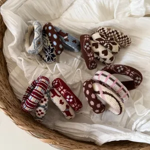 Close-up of four knitted elastic hair ties with diverse heart and geometric patterns