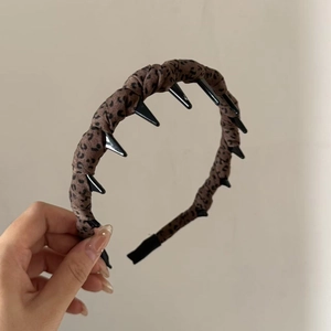 Détail d'un serre-tête en tissu léopard bleu avec dents intérieures pour une fixation