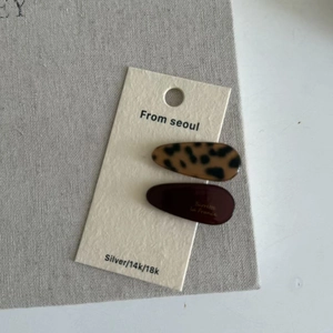 Stylish acetate leopard print and dark brown hair claw clip set on a white card display