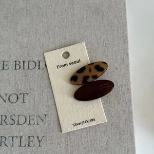 Detail view of oval leopard print and burgundy hair clips on a display card
