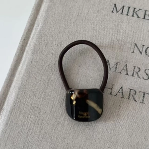French retro acetate hair scrunchie with tortoiseshell geometric charm and golden logo