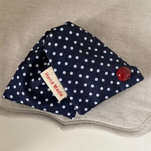 Detail of handmade denim blue polka dot hair claw with red bead and handmade label