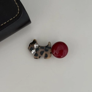 Detail of leopard print dog hair clip with red bead and crystal heart bow decoration