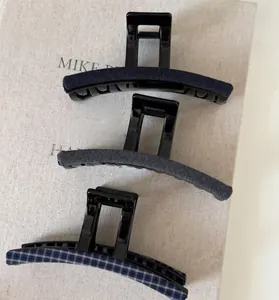 Detailed view of three vintage fabric shark hair clips in blue, grey and plaid patterns