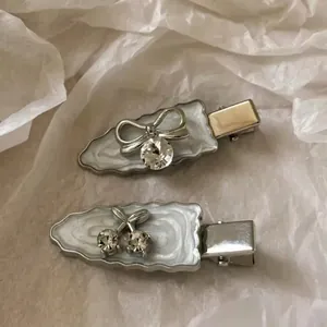 Elegant bow and cherry hair clips with rhinestones on a wavy silver base