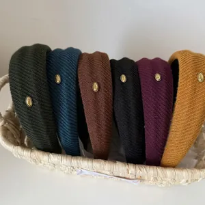 Knitted wide-brimmed padded headbands with gold love labels in six assorted colors