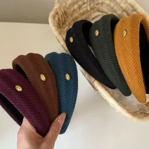Close-up of knitted headbands with gold 'love' labels in various autumn colors