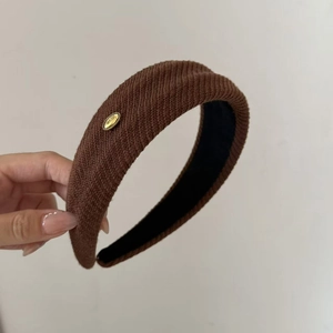 Minimalist dark brown ribbed knit headband with elegant gold love metal charm for women