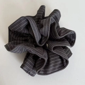 Macro detail of navy blue striped scrunchie fabric with fine stitching and soft pleats