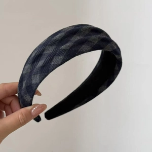 Detail of wide plaid headband featuring navy blue and grey checkered wool fabric texture