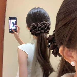 Detail shot of large dark brown rose fabric banana hair clip for low ponytail hairstyles