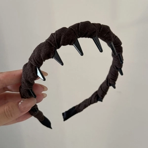 Detail view of brown denim fabric texture and black non-slip plastic teeth on the headband