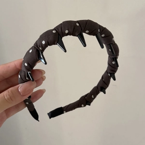 Detail view of denim polka dot headband featuring edgy black spikes for punk style look