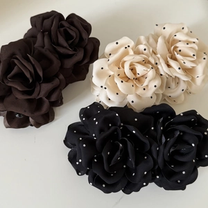 Detailed macro view of three layered chiffon rose hair clips in polka dot and brown patterns