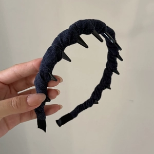 Close-up of denim headband with black conical studs and non-slip tooth design