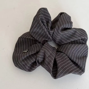 Detailed texture of grey striped fabric scrunchie with round bead decoration