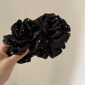 Close-up of handmade coffee brown polka dot rose flowers on a fabric hair clip accessory