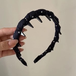 Detail view of the black polka dot headband featuring non-slip inner teeth for secure grip