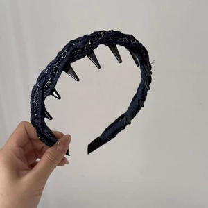 Detail of dark blue denim headband with silver metal chain and large inner teeth
