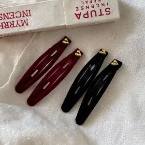 Elegant velvet heart BB hair clips in burgundy and black set on white linen fabric