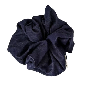 Minimalist navy blue denim scrunchie with high-density fabric texture and brand label