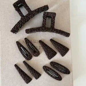 Flat lay of 10-piece leopard print hair accessories with various knit clips and claws