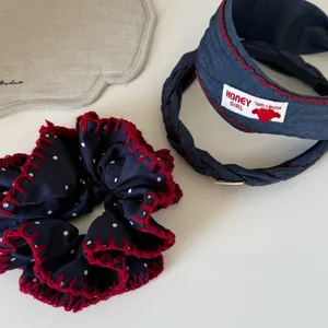 Détail du chouchou en jean et bandeaux avec coutures rouges et motif à pois