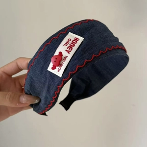 Serre-tête en denim avec coutures rouges ondulées, étiquette et bouton coeur