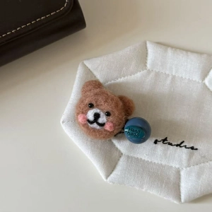 Handmade brown felt bear hair clip with a blue Hand Made decorative ball accessory