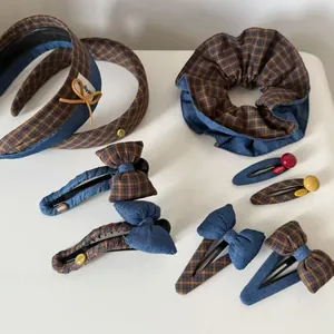 Close-up of denim blue and plaid fabric texture with luckygirl embroidery on hair accessories