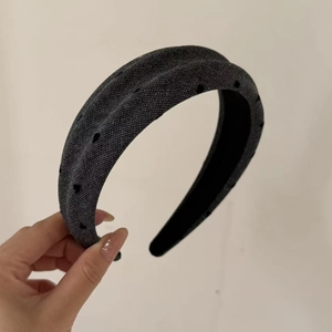 Detail of grey denim fabric headband with a knotted design and black polka dot pattern