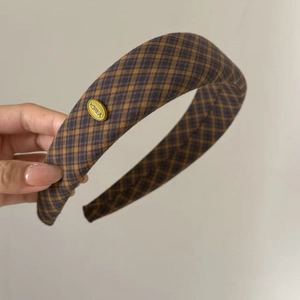 Detail of retro plaid headband with gold Korea metal tag and thick vintage fabric texture