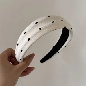 Close-up of the grey heart pattern fabric on a thick padded headband with soft texture