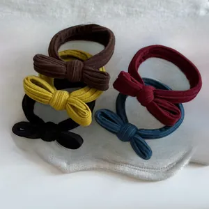 Detailed set of five vintage knit bow hair ties in brown, yellow, red, navy and black