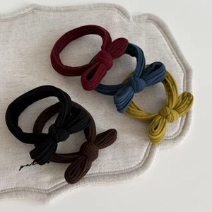 Close-up detail of knitted rib fabric texture on vintage bow hair scrunchies set