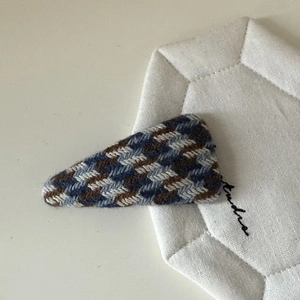 Close-up of houndstooth knit fabric BB hair clip in blue and brown vintage texture
