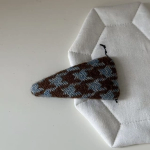 Close-up of brown and blue houndstooth pattern fabric on triangle snap hair clip