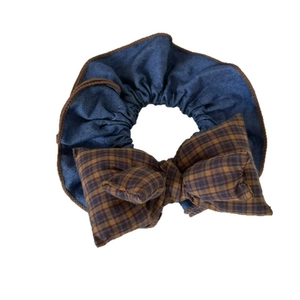 Denim blue scrunchie with a brown plaid bow tie in a vintage preppy hair accessory style